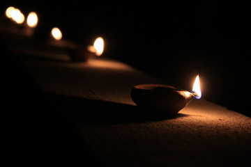 Earthen diya lamp lighting with candles on the occasion of diwali and sandhi pujo.