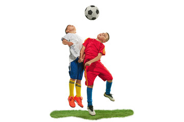 Young boys with soccer ball doing flying kick