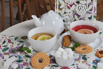 various cookies and biscuits baked at home in a container and tea in a retro cup with free space for text