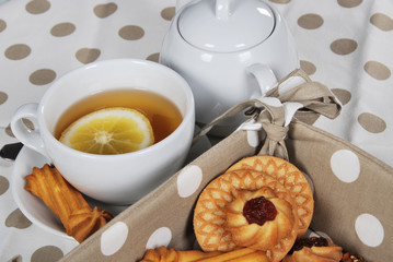various cookies and biscuits baked at home in a container and tea in a retro cup with free space for text
