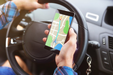 Consulting a route on a smartphone in a car closeup