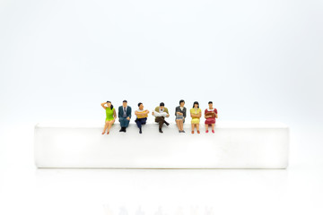 Miniature people, sitting on white block. White block can write anything for various occasions.