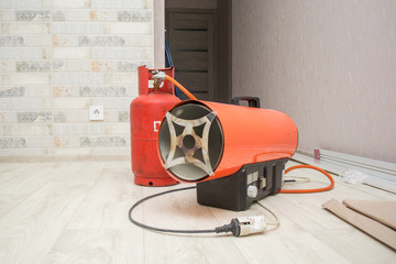 repairmen install stretch ceiling made of pvc vinyl film using a gas heat gun