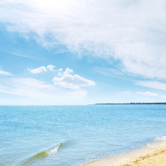 Obraz premium blue sky in white clouds over sea and sand
