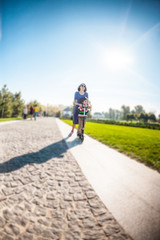 Woman riding with her son on a scooter.