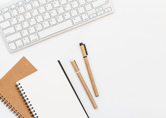 Blank notebook, pen and keyboard on white background