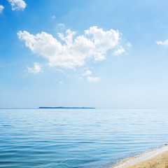 Fototapeta na wymiar blue sky with white clouds over sea and island on horizon
