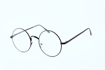 Round black-rimmed glasses are located frontally on a white background. Isolated. side view