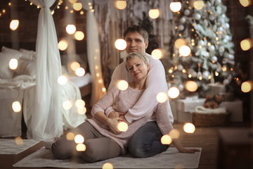 Fototapeta na wymiar Husband his wife. Cozy bedroom Christmas interior