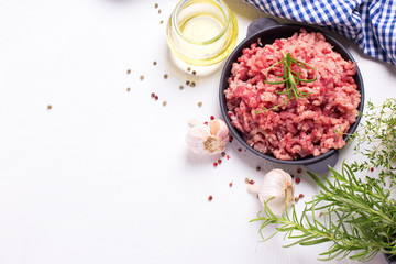 Obraz na płótnie Canvas Raw minced meat in bowl with ingredients for cooking
