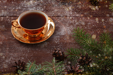 Cup of coffee with gold color on wooden background. New year holiday, Christmas. The concept of holiday and recreation.