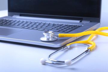 Workplace of doctor with laptop, stethoscope and RX prescription on white table. top view.