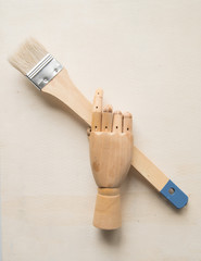 Wooden artist's hand mannequin with artist's brush