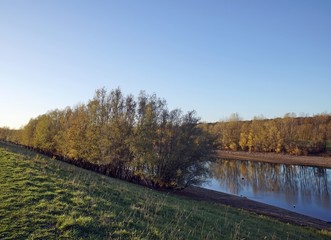 Herbstspiegelung am alten Rheinarm in Wesel am Niederrhein bei Niedrigwasser