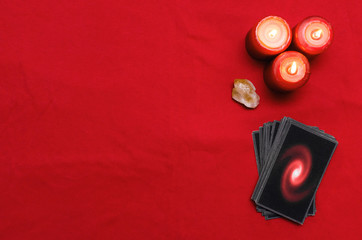 Tarot cards on the red table cloth on fortune teller table background. Futune reading concept.
