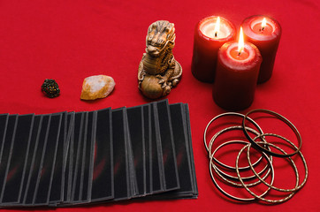 Tarot cards on the red table cloth on fortune teller table background. Futune reading concept.