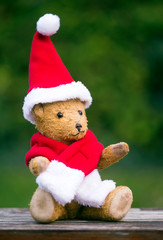 Happy christmas toy teddy bear wearing red santa hat - gift for children