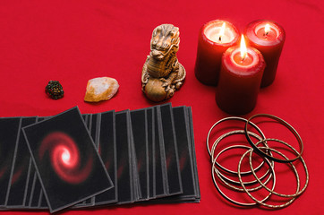 Tarot cards on the red table cloth on fortune teller table background. Futune reading concept.