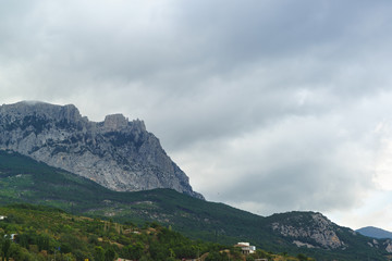 Fototapeta na wymiar The jags of AI-Petri mountain above the village of Alupka. Grey day on the southern coast of Crimea