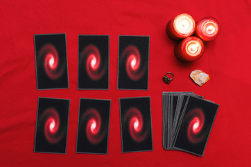 Tarot cards on the red table cloth on fortune teller table background. Futune reading concept.