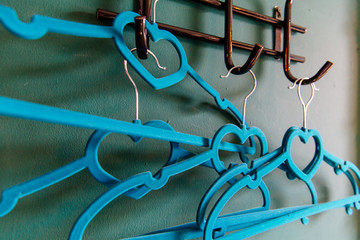 blue рeart clothes hanger on green background. two clothes hanger being in love,lovely concept.