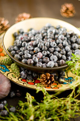 Blueberries on the plate with figs and herbs on the Brown wooden background