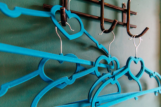 blue рeart clothes hanger on green background. two clothes hanger being in love,lovely concept. - Powered by Adobe