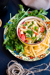 Pasta of tomato pesto and green on the yellow plate