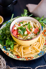 Pasta of tomato pesto and green on the yellow plate