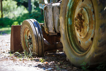 Old rusty abandoned tractor on the street of Georgia. Authenticity of the Georgian village