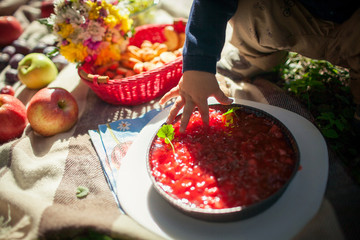 A baby's finger touches a berry dessert during a picnic.
