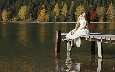 Fototapeta na wymiar Runaway bride wearing sneakers felling free resting on a wood dock