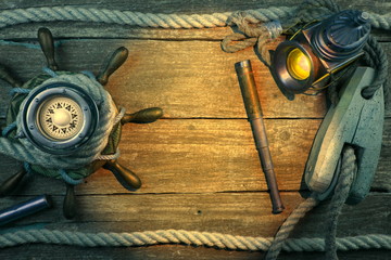 Old ship steering wheel,compass,coins,monocle,loupe, sextants,rope. Travel and marine engraving...