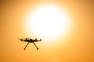 Flying drone on the background of the solar disk.