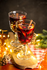 Christmas composition with spicy mulled wine, led lights and pine cones on dark background
