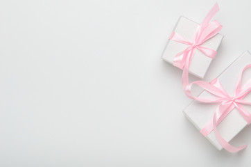 Gift boxes with pink ribbon on white background. Concept holiday gift, congratulations. Top view, copy space, flat lay.