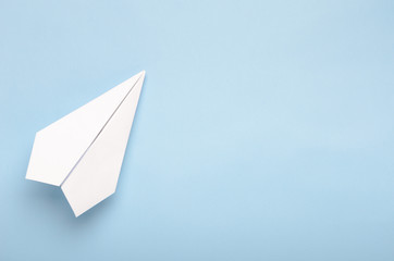 Paper plane on a blue background. Concept of flight, travel, transfer. Top view, copy space, flat...