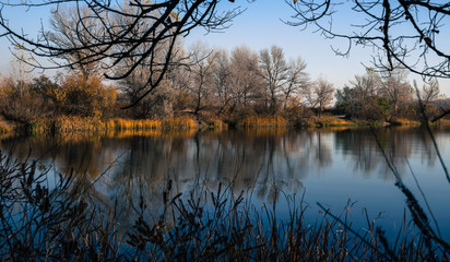 Beautiful autumn landscape. Trees reflected in the water of the lake