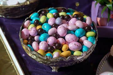 Sweet , colorful candies,chocolates around of them . colored candy in bowl.