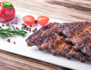 baked ribs on white plate with tomatoes and spices
