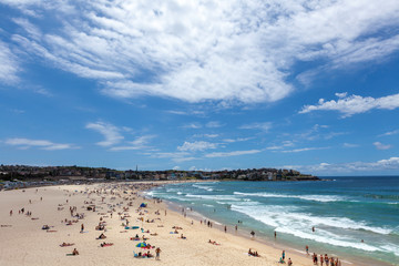Wave breaks and surf on clear sand of famous Australian Sydney Bondi beach