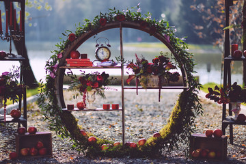 set of autumn wedding decor outdoors. Floral arrangement of flowers and fruits. details of the...