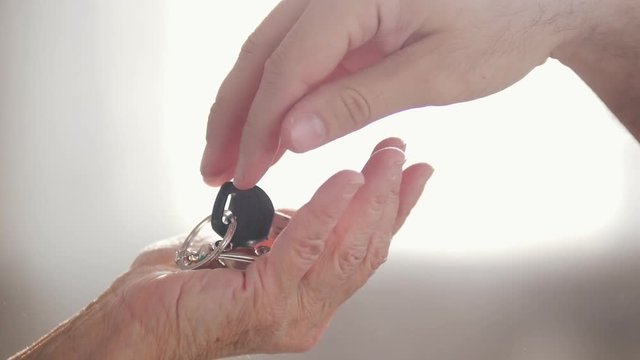 Car key chain on hand. Pass from hand to hand