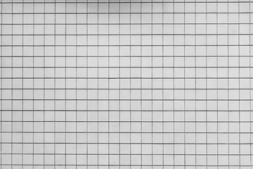 Weiße Wand mit quadratischen kleinen weißen Fliesen nutzbar als Hintergrund oder Textur.