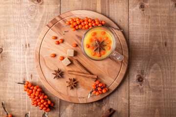 Sea-buckthorn berries and spice on wooden background. Rustic style. Top view