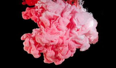 Fototapeta premium Spill and mix paint in water of red and white colors, isolated on a black background