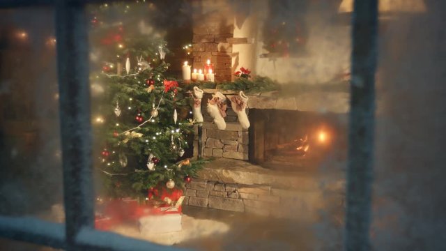 Christmas tree scene through frozen window. Traditional scene with presents under the tree and fire in fireplace. Decorated living room and candle light and socks with presents on fireplace sims.