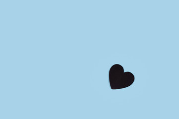 Black heart shape on a blue paper background.