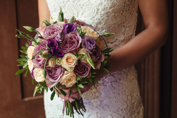 young beautiful bride in white dress holding wedding bouquet, bouquet of bride from rose cream...