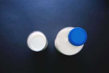 bottle and glass of milk isolate on dark background top view